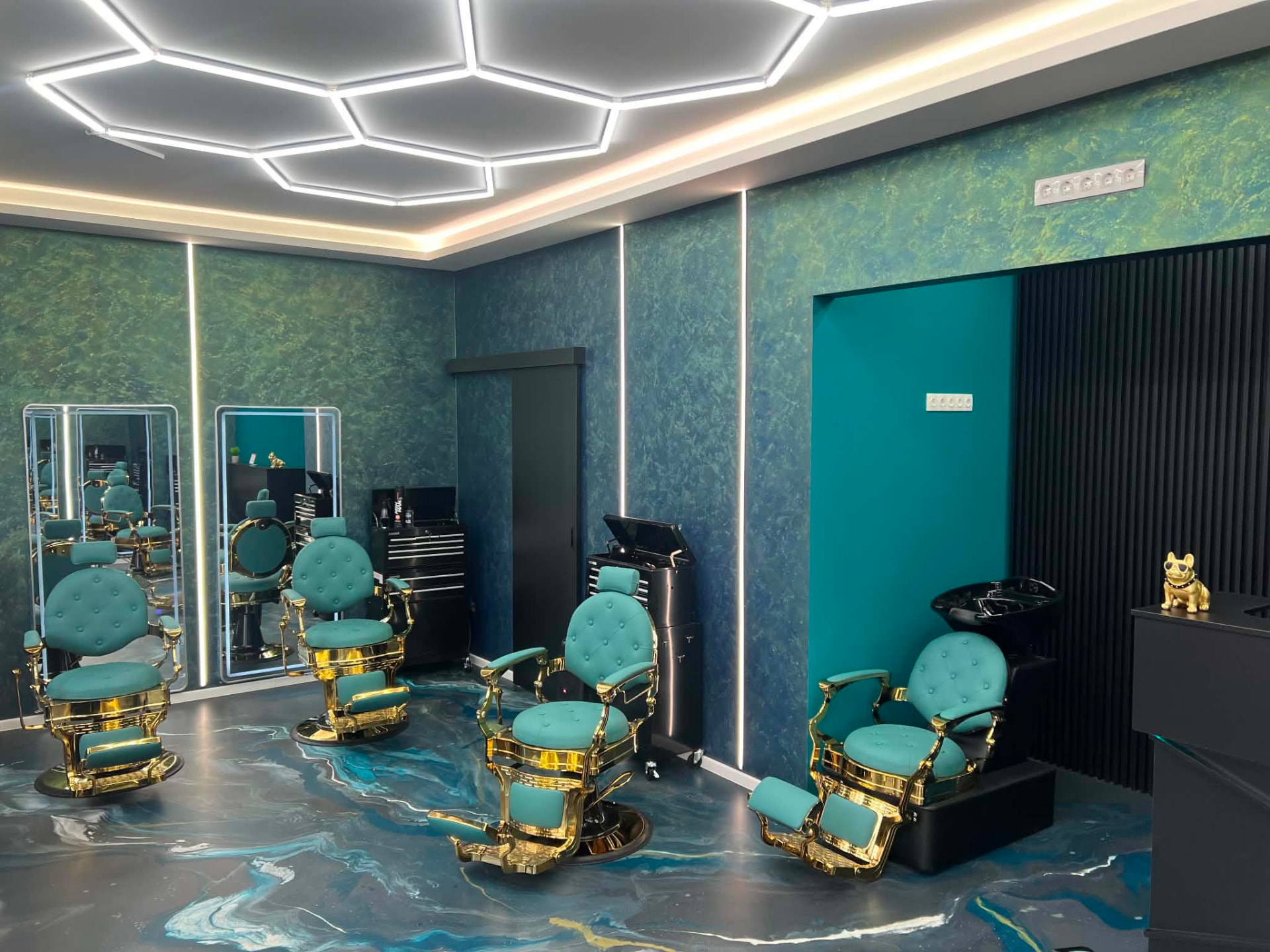 A Müller Cut Barbershop belső tere – prémium zöld-arany székek és modern világítás